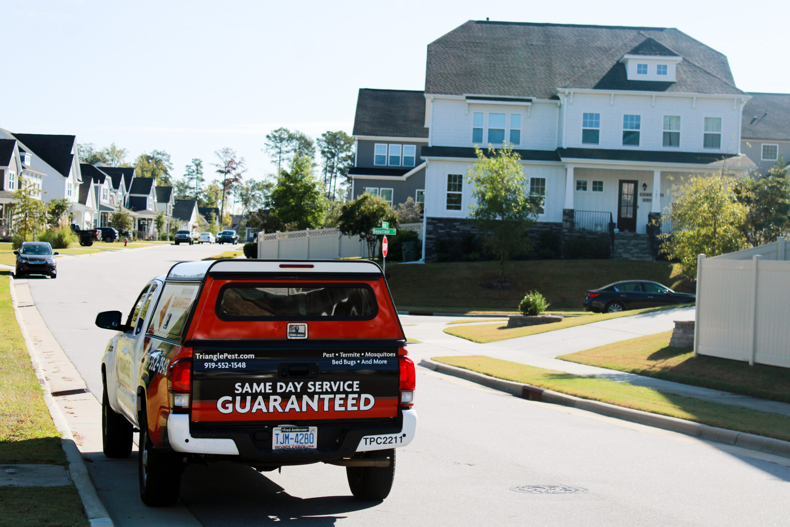 Professional termite control service in Raleigh with Triangle Pest Control truck in residential neighborhood